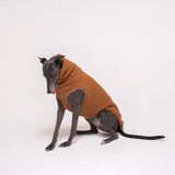 Greyhound dog wearing Snootly fluffy reversible sleeveless sweater in caramel on white background