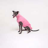 Greyhound dog wearing Snootly fluffy reversible sleeveless sweater in marshmallow pink on white background