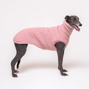 Greyhound dog wearing Snootly fluffy reversible sleeveless sweater in marshmallow pink on white background