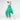 Italian greyhound dog wearing a fluffy reversible onesie in green sitting