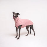 Greyhound dog wearing Snootly fluffy reversible sleeveless sweater in marshmallow pink on white background
