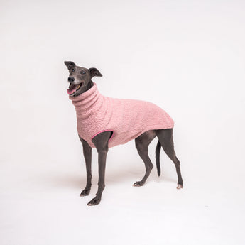 Greyhound dog wearing Snootly fluffy reversible sleeveless sweater in marshmallow pink on white background
